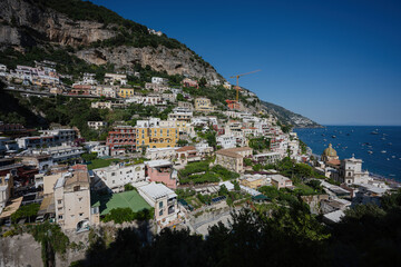 Fototapeta na wymiar Positano with hotels and houses on hills leading down to coast, comfortable beaches and azure sea on Amalfi Coast in Campania, Italy.