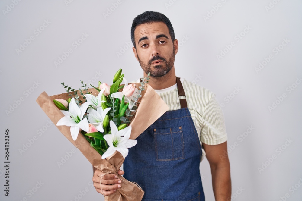 Sticker hispanic man with beard working as florist looking sleepy and tired, exhausted for fatigue and hango