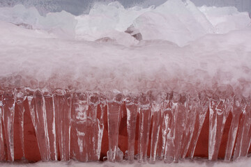 large icicles on a red background. Winter and frosts