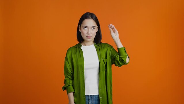 Irritated Asian woman makes blah-blah gesture and rolls eyes