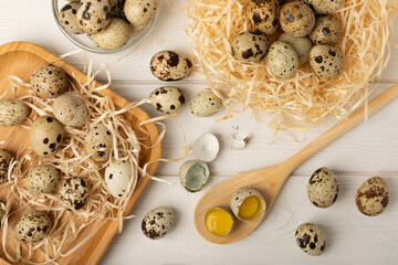Quail eggs raw and boiled on a white wooden background. Healthy food. Diet. top view. free space.