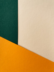 Abstract colourful paper background on office table with texture. Green, beige, orange