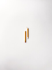 Cracked yellow pencil with red rubber tip isolated on a white background