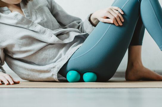 Person doing self myofascial release on gluteus muscles with two therapy balls