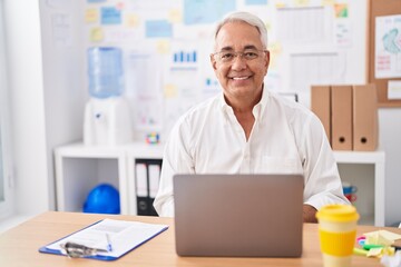 Middle age grey-haired man business worker using laptop working at office