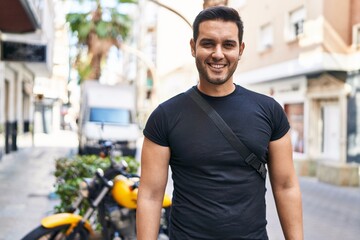 Young hispanic man smiling confident standing at street