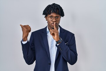 Young african man with dreadlocks wearing business jacket over white background asking to be quiet...