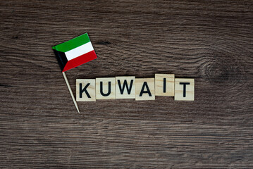 Fototapeta na wymiar Kuwait - wooden word with kuwaiti flag (wooden letters, wooden sign)
