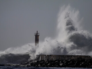 Fototapeta na wymiar Big stormy wave splash over beacon