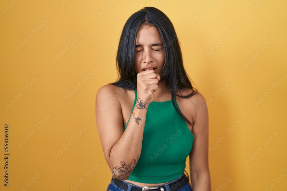 Canvas Prints Brunette woman standing over yellow background feeling unwell and coughing as symptom for cold or bronchitis. health care concept.