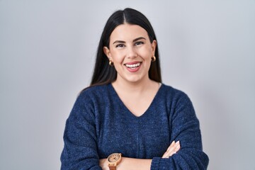 Fototapeta premium Young brunette woman standing over isolated background happy face smiling with crossed arms looking at the camera. positive person.