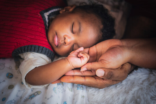 Blurred soft images of an African Baby's hand Placed on the mother and father's hand, concept to showing love and concern for her children, and is love family relationship.