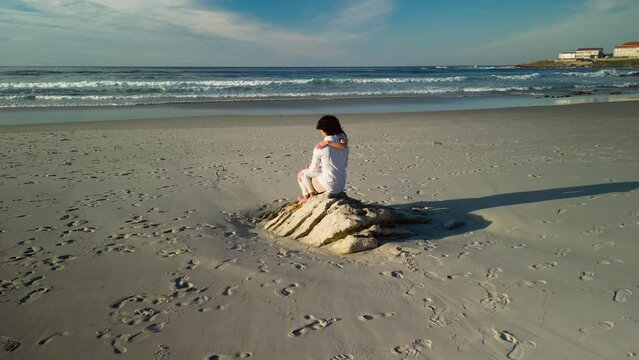 Approaching Towards Romantic Couple On The Sandy Shore Of Praia de Caion In Spain. Aerial Drone Shot