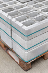 Fototapeta na wymiar Pallet of Concrete Cinder Blocks, Grey Uniformed brick Shapes building material. New for use on construction site in Israel.