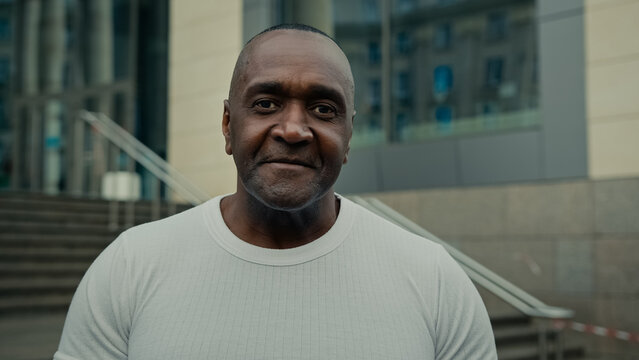 Ethnic middle-aged senior mature adult 50s friendly man African American business advisor smiling male face outdoors in city looking at camera. Businessman 40s entrepreneur broker company CEO portrait - Powered by Adobe