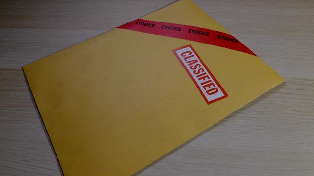SEALED EVIDENCE ENVELOPE MARKED "CLASSIFIED" DROPS INTO FRAME.  4K.  NO PEOPLE.