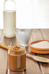 Jar of Dulce de leche, traditional sweet from Argentina on wooden table.