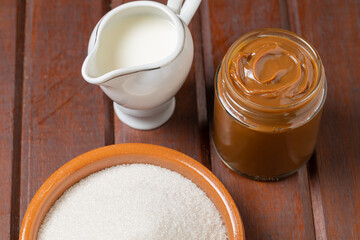 Dulce de leche, traditional sweet from Argentina with milk an sugar on wooden background.