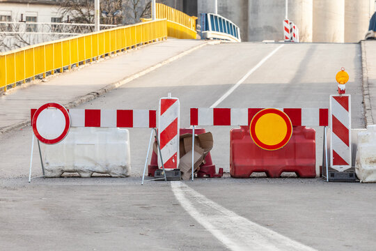 Selective blur on road barriers and no traffic signs, European standard, in front of a road being blocked for road repair and reconstruction in an urban environment...