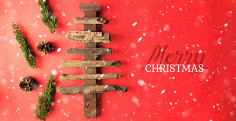 Wood stick rustic Christmas tree on red background for happy holiday greeting.