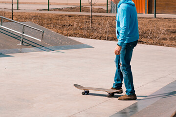 Adult skateboarder over 50 years old in blue hoodie and jeans decides to skateboarding in...