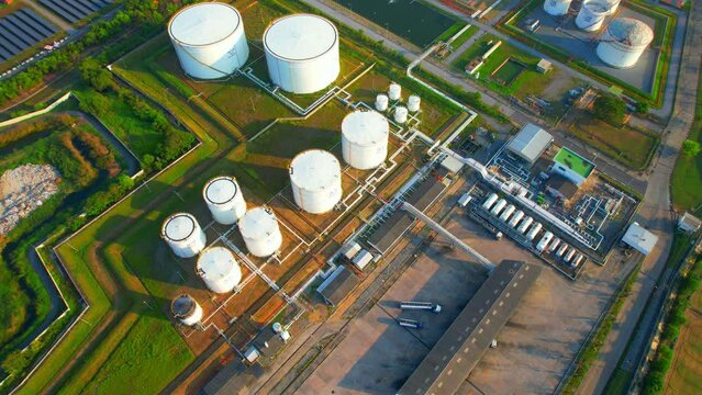 Aerial view above the oil storage tanks on the ground in oil distribution station. world economy oil field. southeast Asia. oil and gas industry. Fossil fuel energy concept. Drone. 4K
