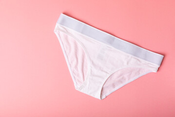 Women's underwear. Different women's underpants on a pink background. A piece of clothing for a person. View from above . place for text.