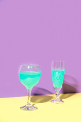 Two glasses of wine. The concept design of the celebration. Minimalistic trendy style. Yellow, Turquoise, Purple color.