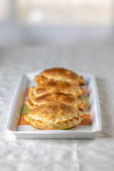 Argentinian empanadas baked on a platter.