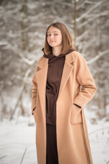 Portrait of a young beautiful girl in the winter forest.