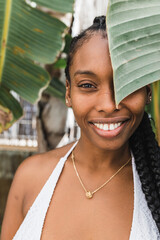 Cheerful black woman with eye covered with leaf