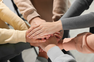 Group of people holding hands together indoors, closeup. Unity concept