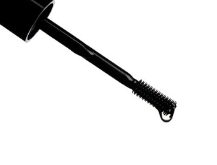 Drop of eyelash oil falling down from brush on white background