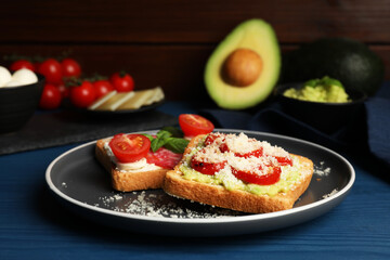 Tasty toasts with different toppings served on blue wooden table