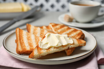 Tasty toasts with butter on light grey table, closeup