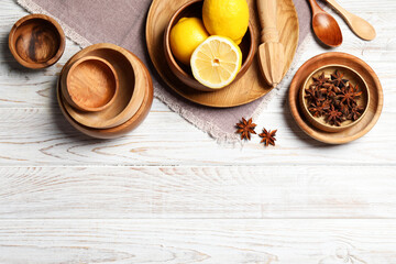 Beautiful tableware, lemons and anise stars on white wooden table, flat lay. Space for text