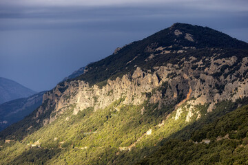 Fototapeta premium Rocky Mountain Landscape Background. Sunset Sky with Sunrays. Near Dorgali, Sardinia, Italy.