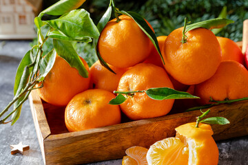 Fresh tangerine fruits or tangerines with leaves in the wooden box