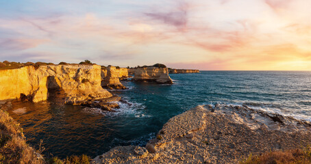 Picturesque seascape with cliffs, rocky arch and stacks (faraglioni), at Torre Sant Andrea in morning sunlight, Salento sea coast, Puglia, Italy.