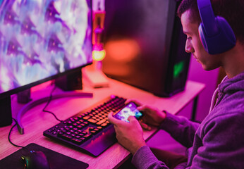 Young boy play video games at home while using computer and mobile phone