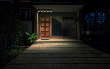 A contemporary residential building's entrance with wooden door night view. Athens, Greece. .