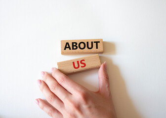 About us symbol. Wooden blocks with words About us. Beautiful white background. Businessman hand....