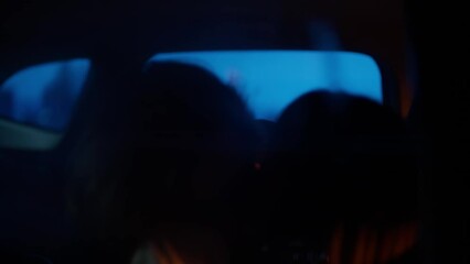 Mid 20s Caucasian couple passionately kissing on a backseat of a car