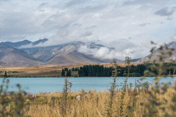 Lake Tekapo mit Bergen und Wolken im Hintergrund.