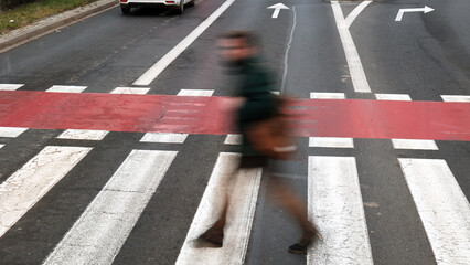 Człowiek na przejściu dla pieszych przez drogę szybkiego ruchu.  - obrazy, fototapety, plakaty