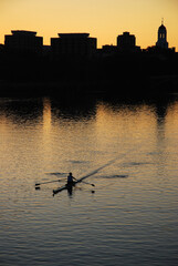 A lone rower plies the waters of the Charles River near Harvard University in Cambridge - Boston...