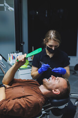 Orthodontic treatment of teeth. The doctor installs metal braces on the patient's teeth. Oral care....