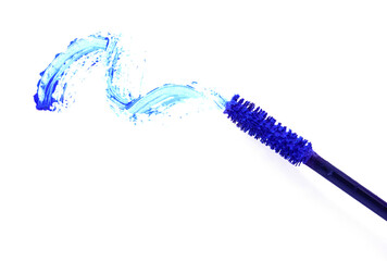 Applicator and blue mascara smear on white background, top view