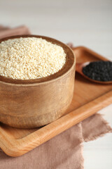 Different tasty sesame seeds on white wooden table