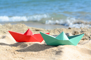 Two paper boats near sea on sunny day